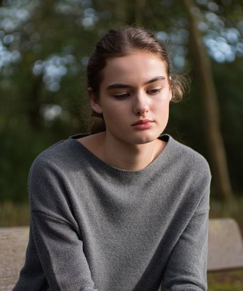 Девушка сидит в лесу